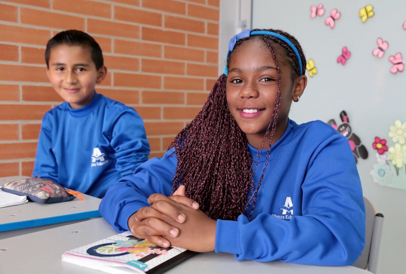 Dos estudiantes frente a sus pupitres