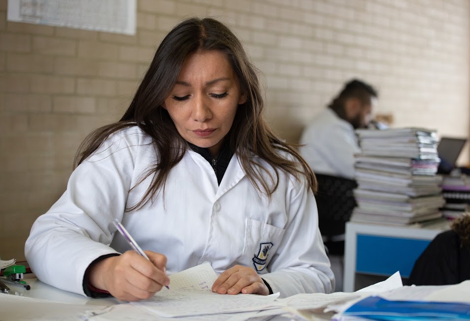 Docente escribiendo en una hoja
