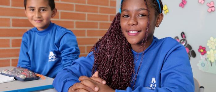 Dos estudiantes frente a sus pupitres 